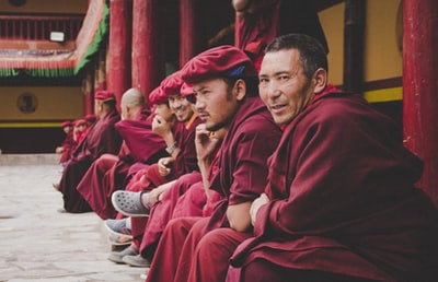 一群穿着红裙子的男人坐在寺庙里微笑着自拍